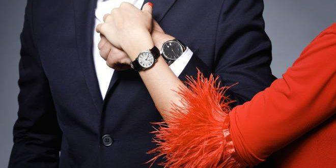 Close-up of couple hands. Well dressed stylish man and woman wearing wristwatches.